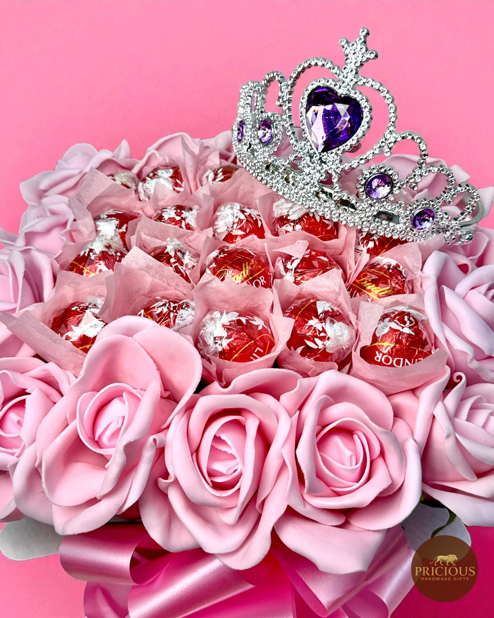 Close-up of tiara and Lindor truffles in pink bouquet