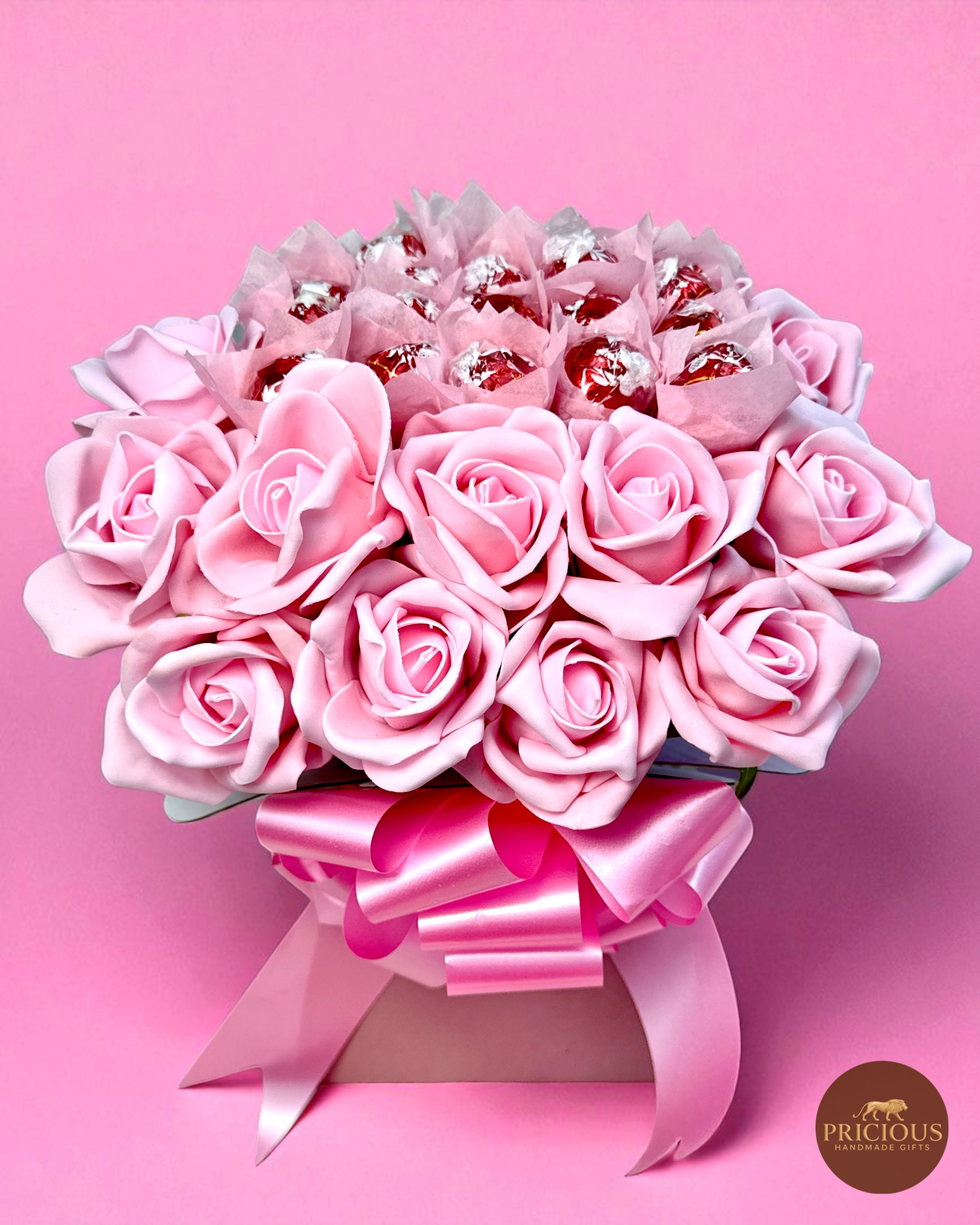 Top view pink rose bouquet box with red-wrapper Lindor truffles