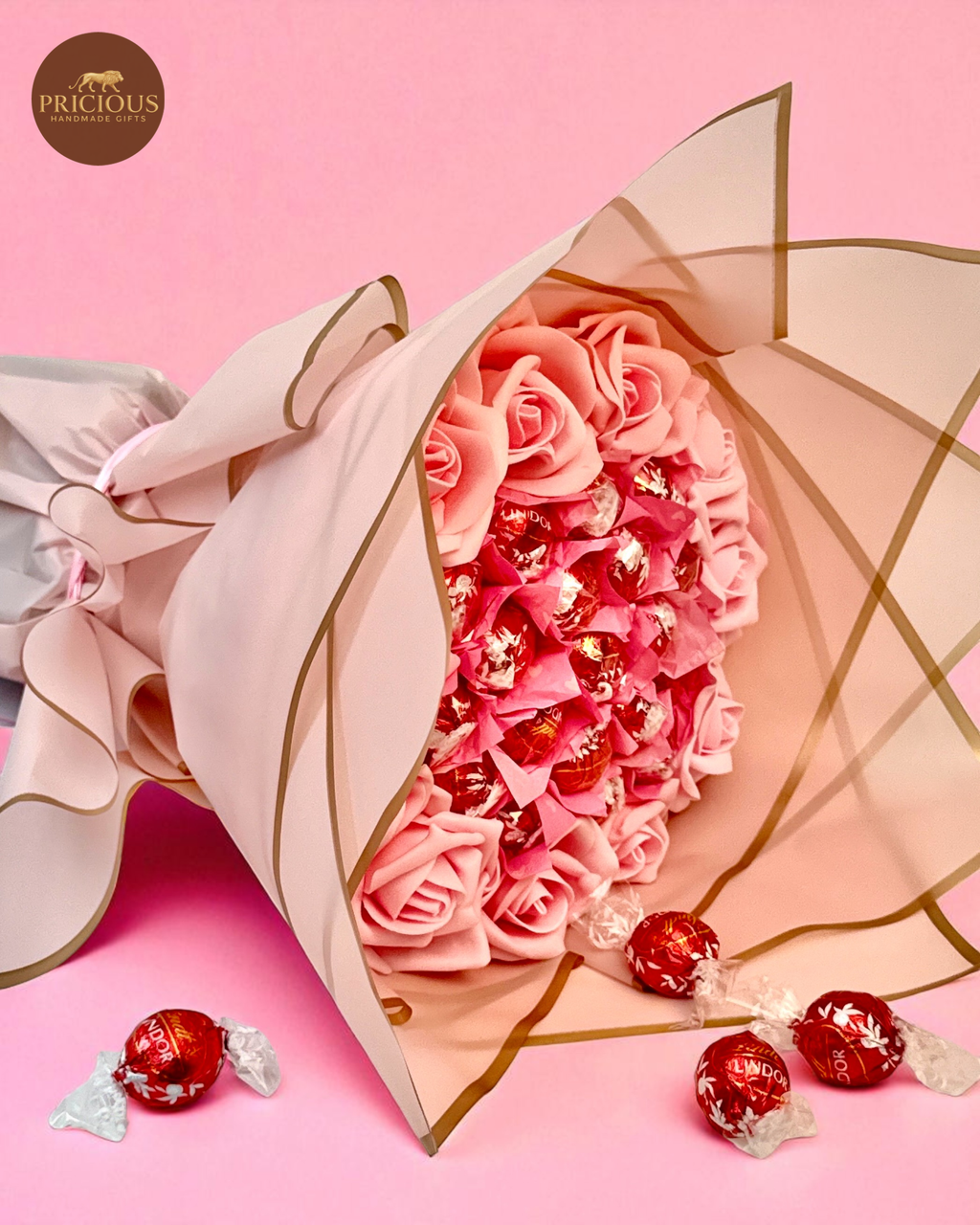 Side view pink rose & Lindor truffle bouquet in blush wrap