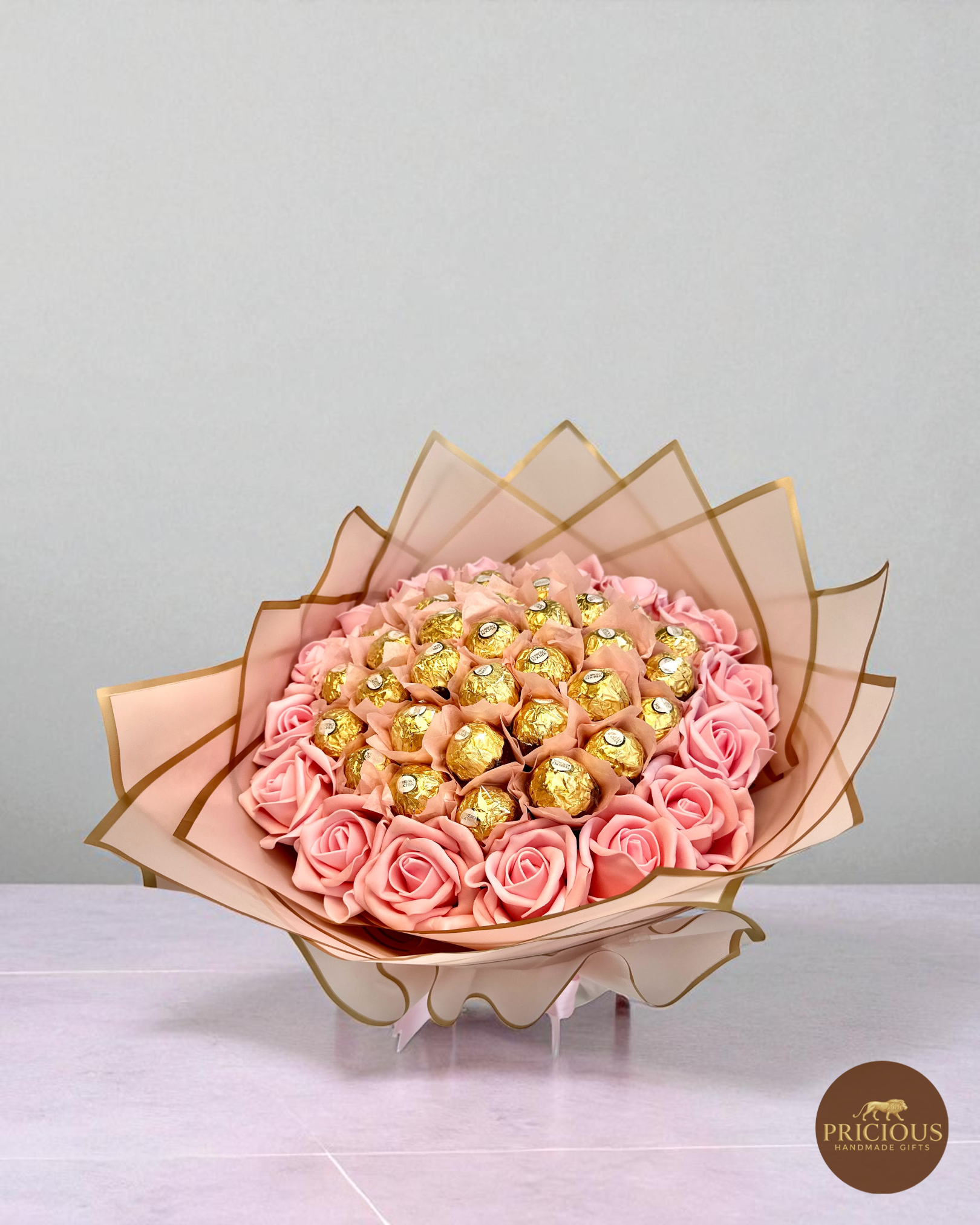 Top view Ferrero Rocher & pink roses bouquet with gold-edged wrap