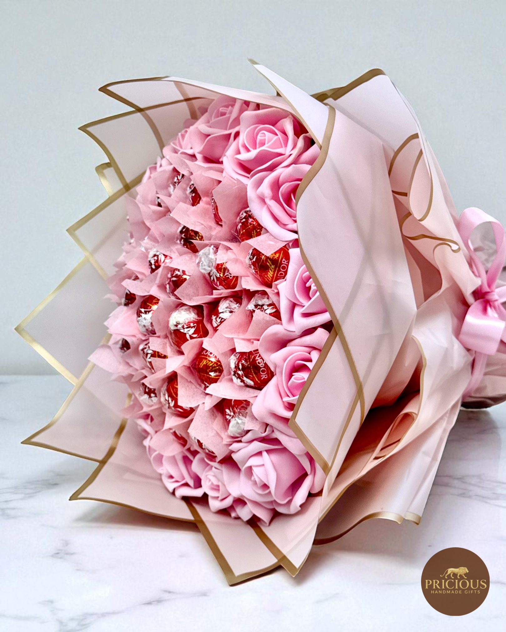 Side view Lindt chocolate bouquet with pink roses and satin bow