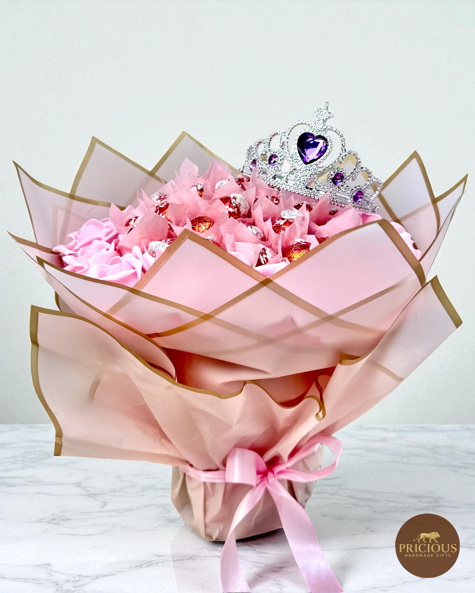 Side view Lindt Lindor truffle bouquet, pink roses & gold-edge wrap