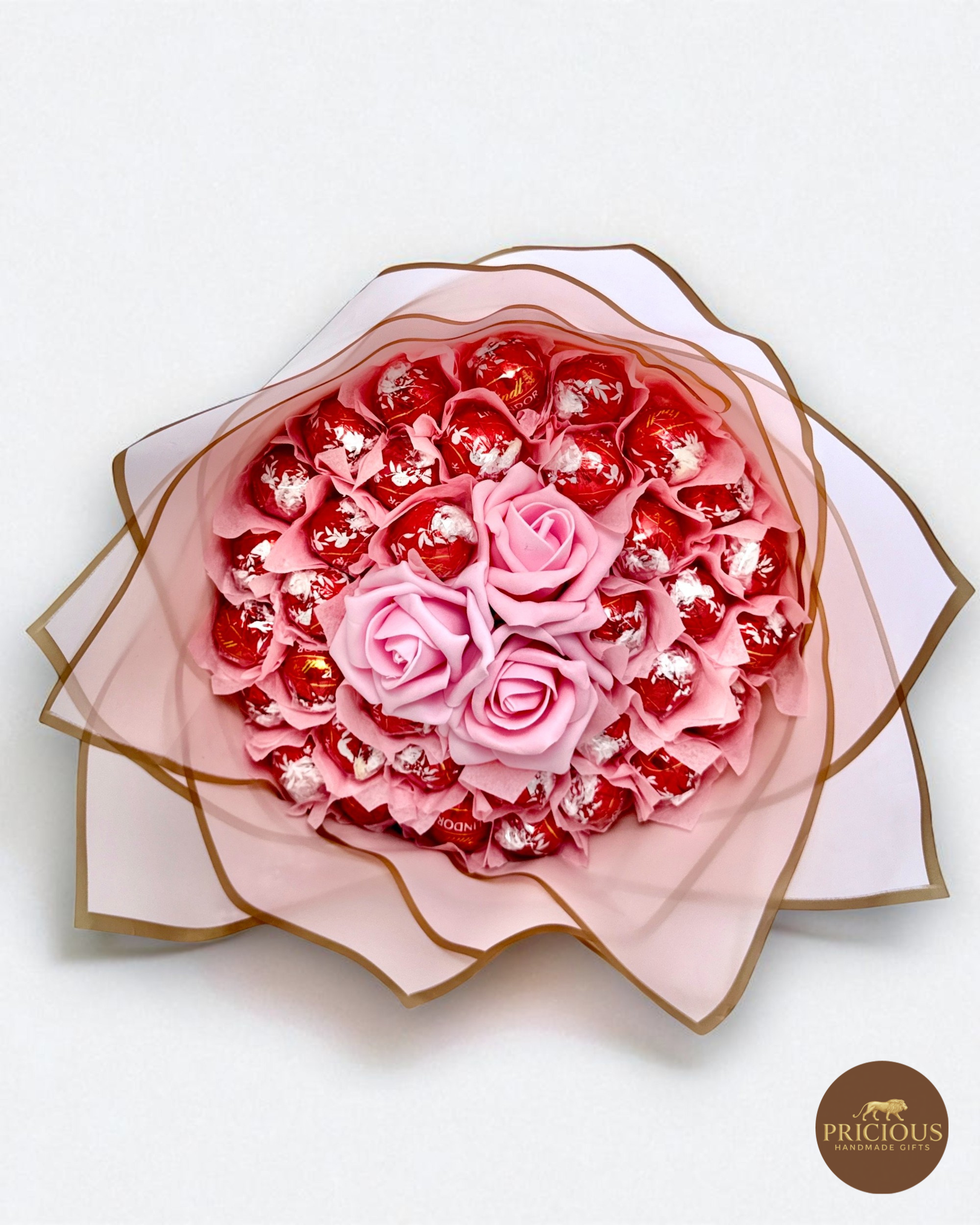 Front view Lindor truffle gift bouquet with pink roses and bow