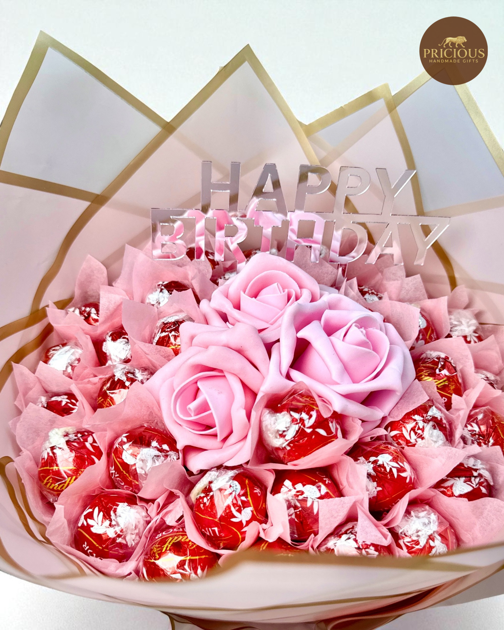 Top view of Lindor birthday bouquet with pink roses and topper