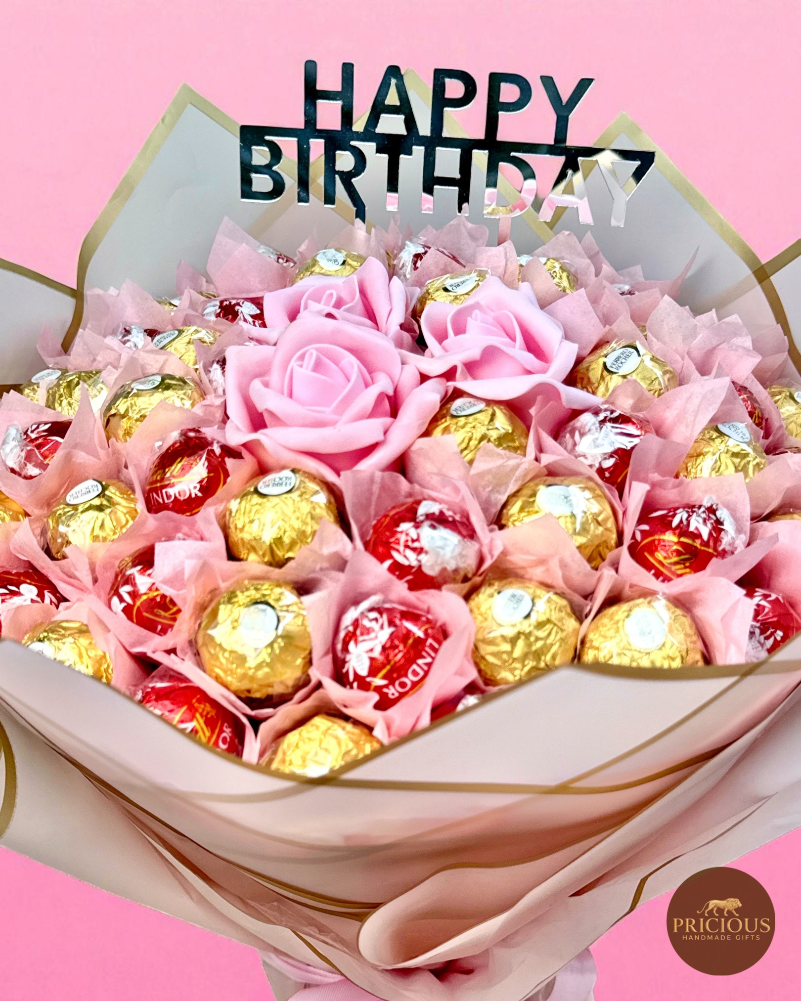 Close-up of mixed Lindor truffles and Ferrero Rocher in pink wrap