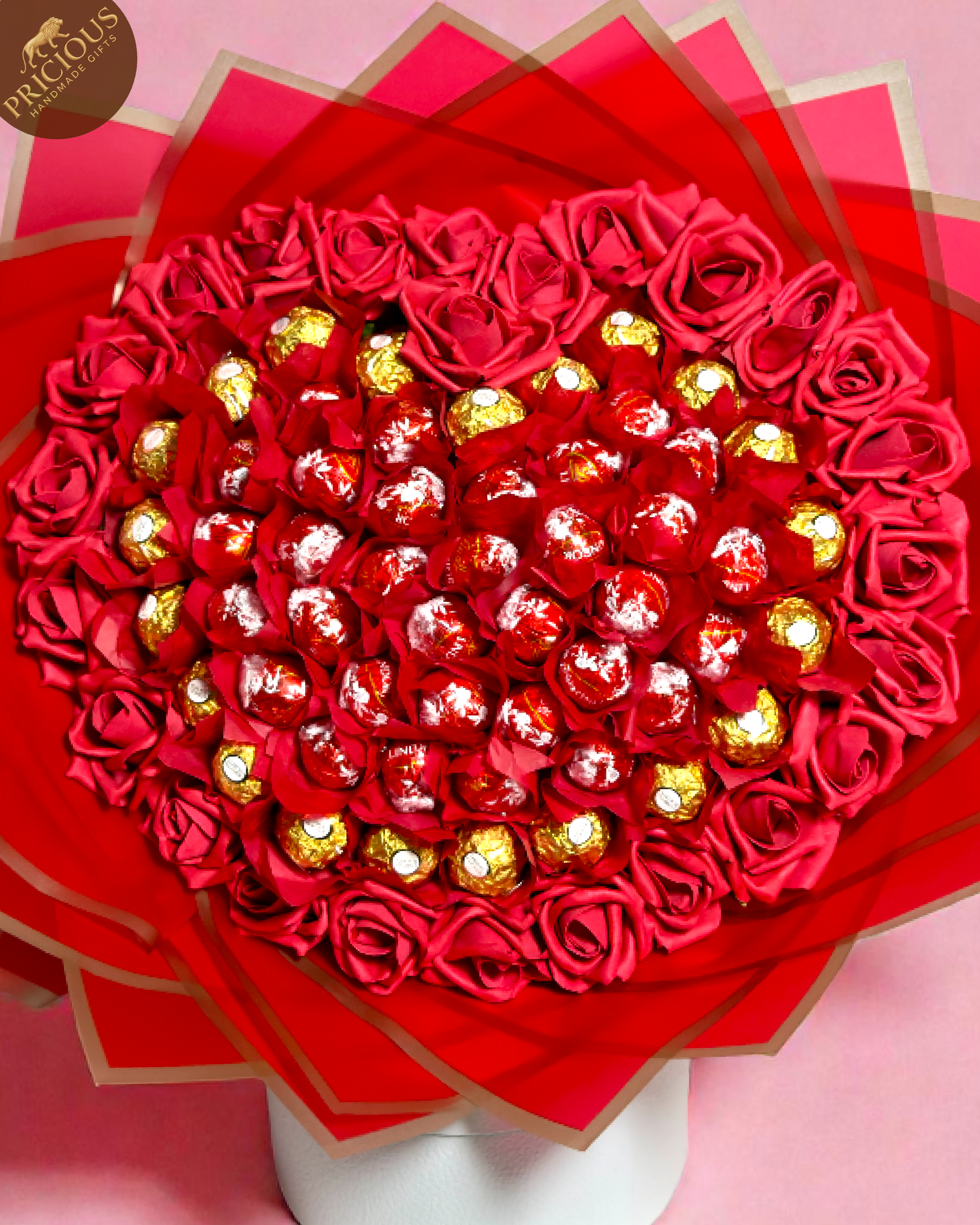 Bouquet of red roses Lindor and Ferrero Rocher chocolates arranged in a heart shape in a red wrap.