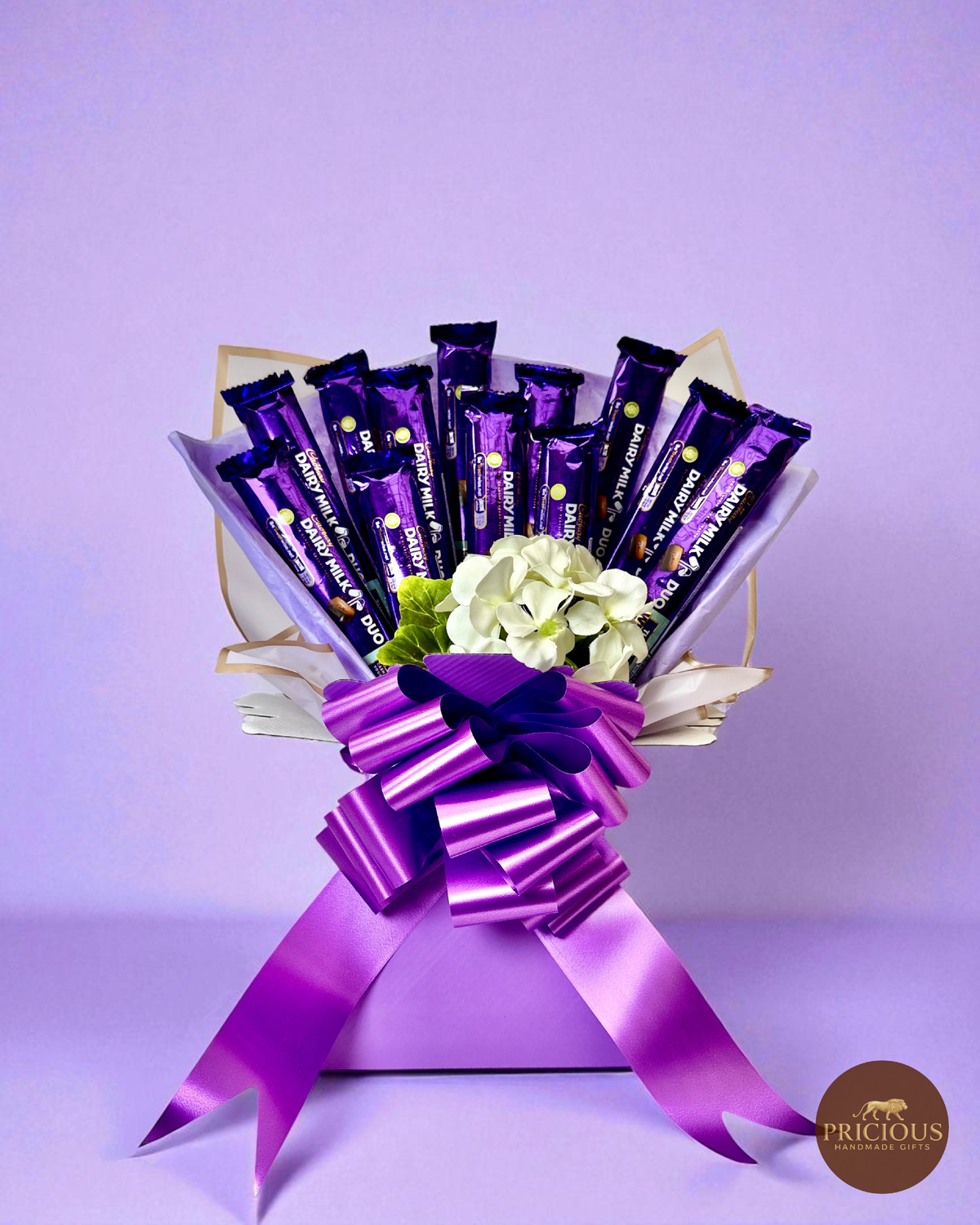 Cadbury Dairy Milk chocolate bouquet in royal purple with ivory flowers and satin bow