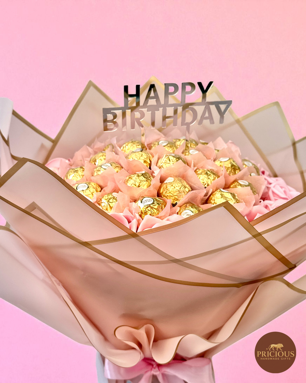 Close-up of gold-wrapped Ferrero Rocher with pink roses