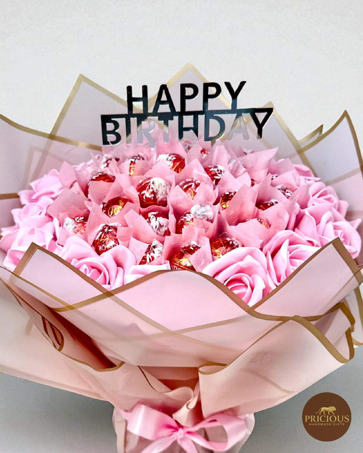 Close view Lindor birthday bouquet with pink roses and topper
