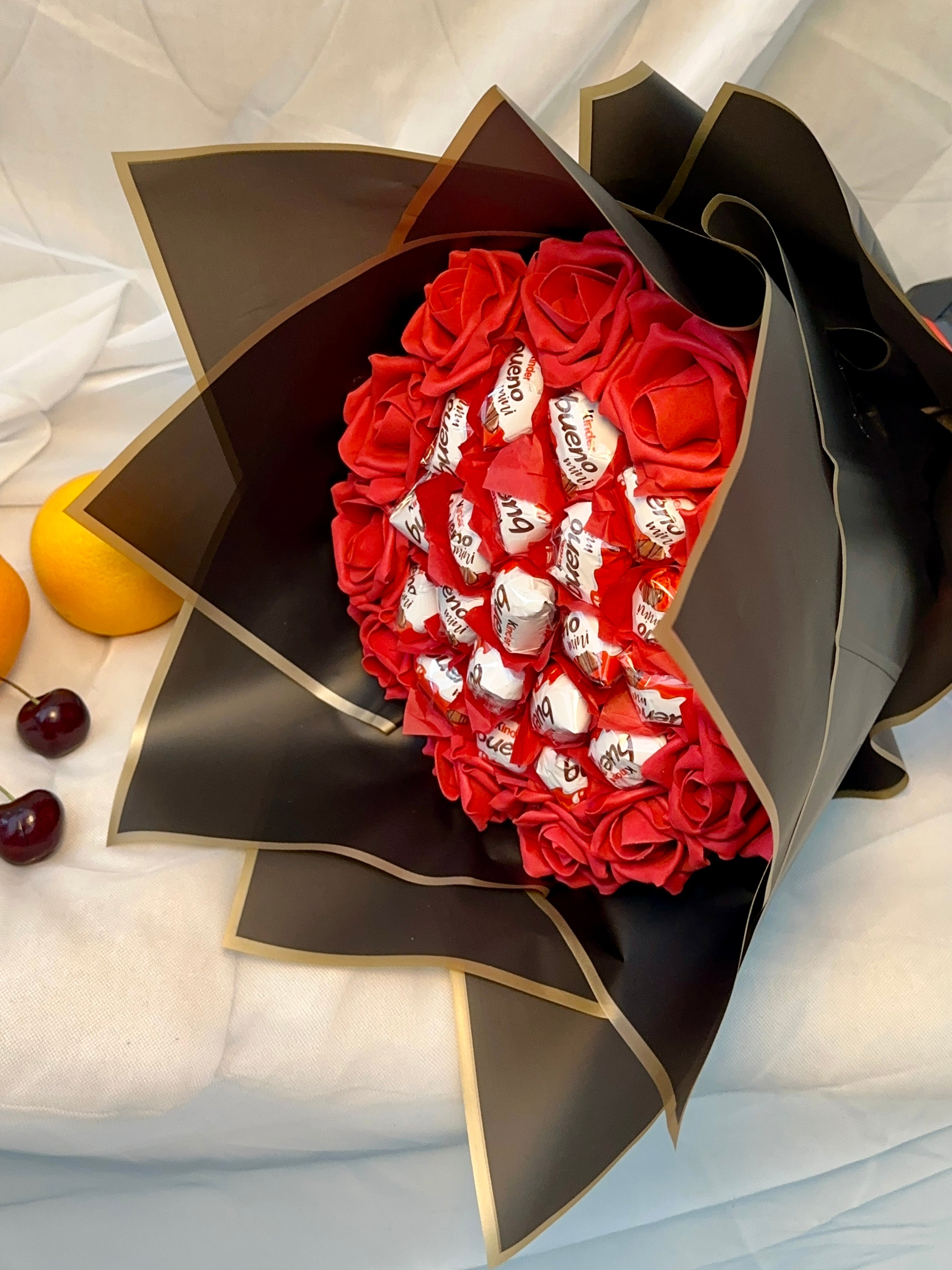 Bouquet of red roses with white heart-shaped cards in a black decorative box on a light background.