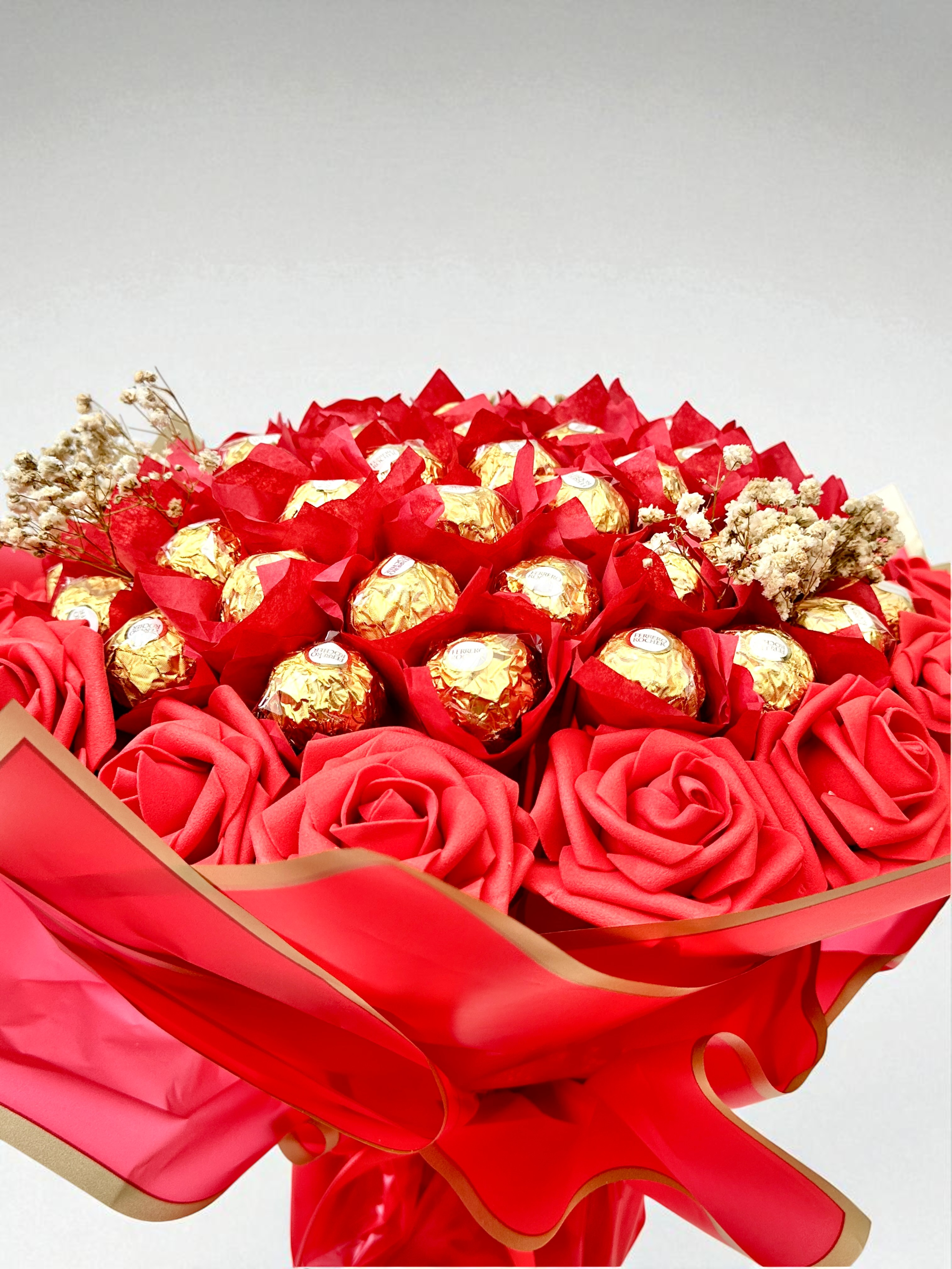 Bouquet of flowers with chocolates and a card on a beige background