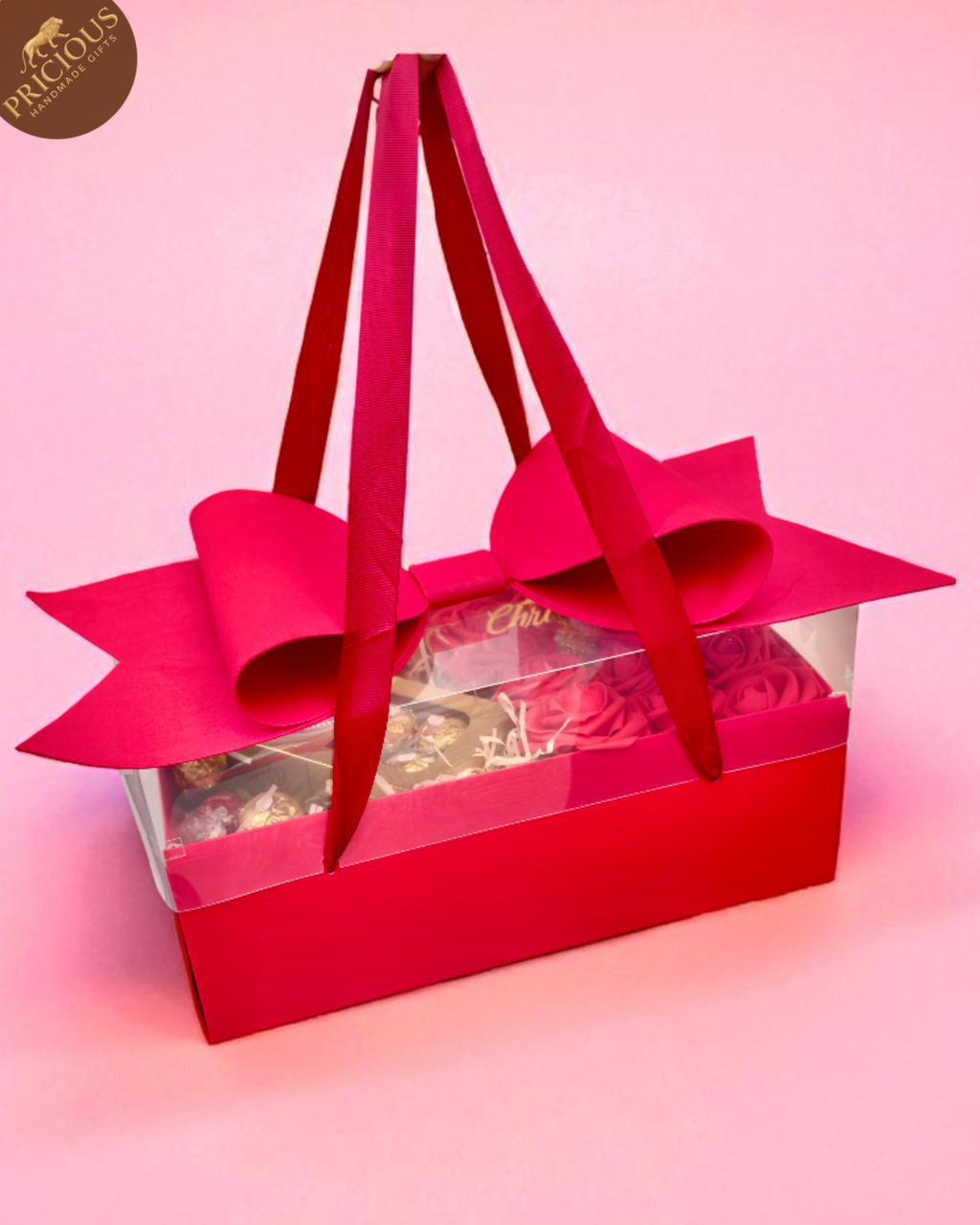 Red gift box with a large bow on a pink background