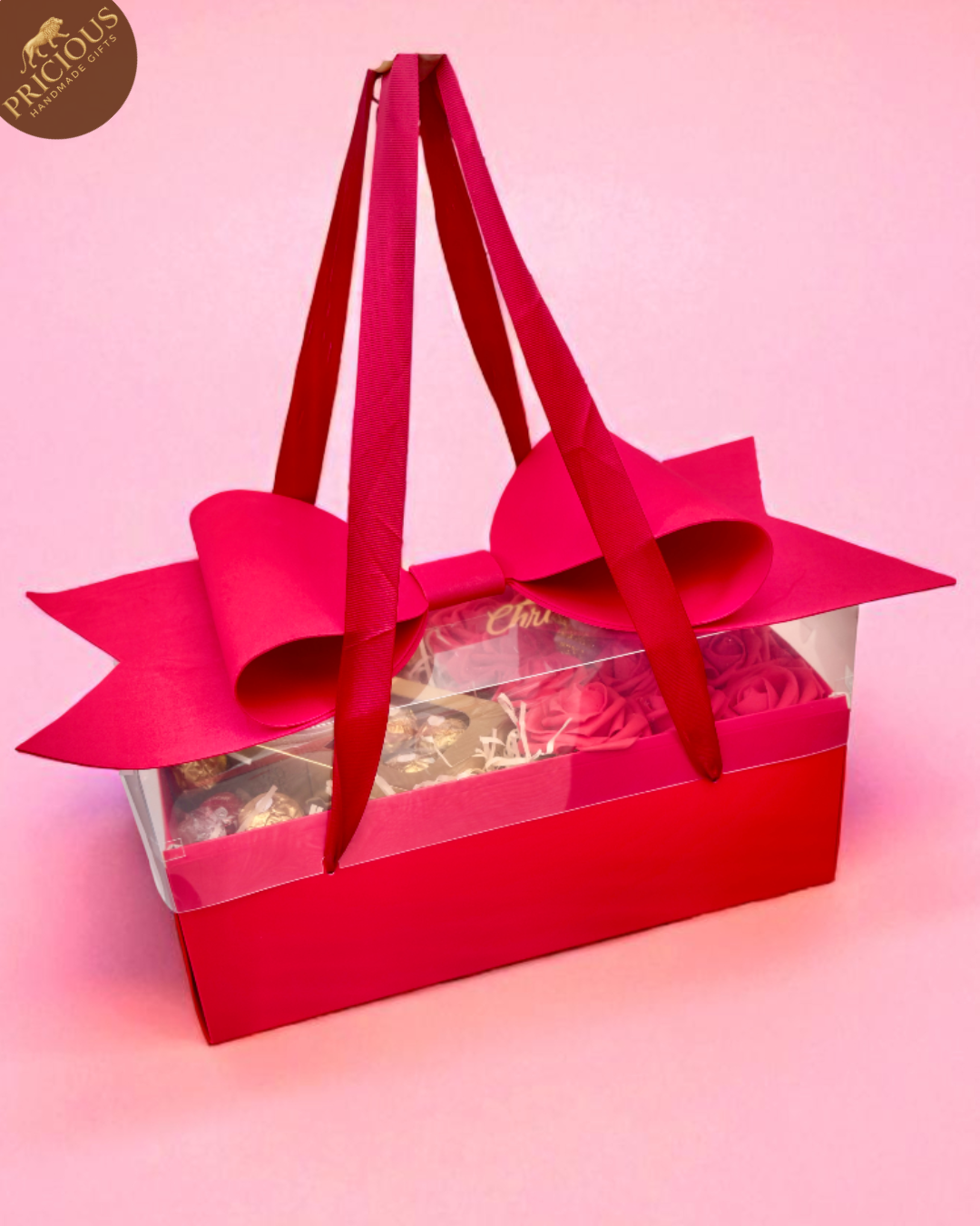Red gift box with a large bow on a pink background