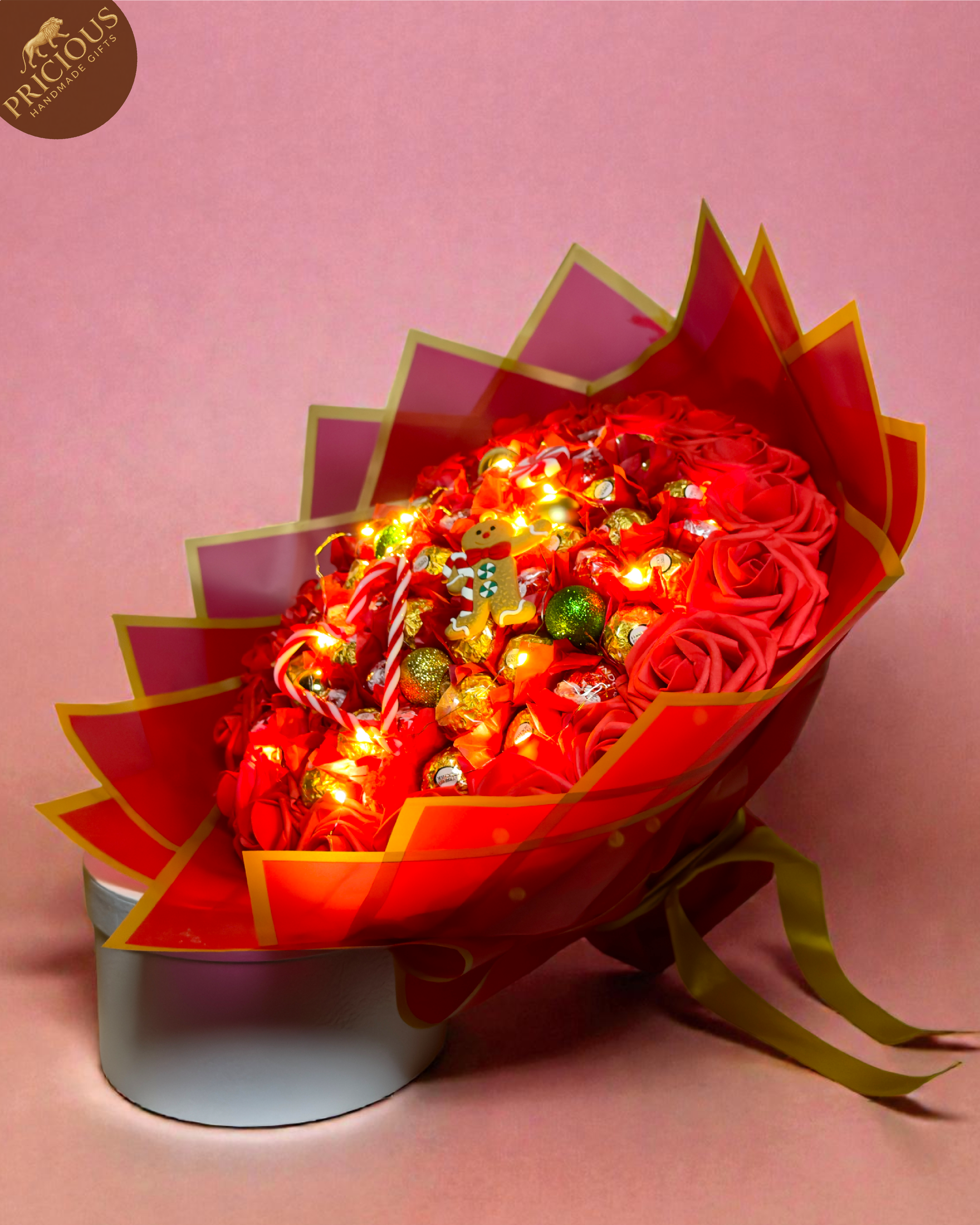 Hand-tied Christmas chocolate bouquet with Ferrero & Lindt, foam roses, LED lights, red & gold wrap.