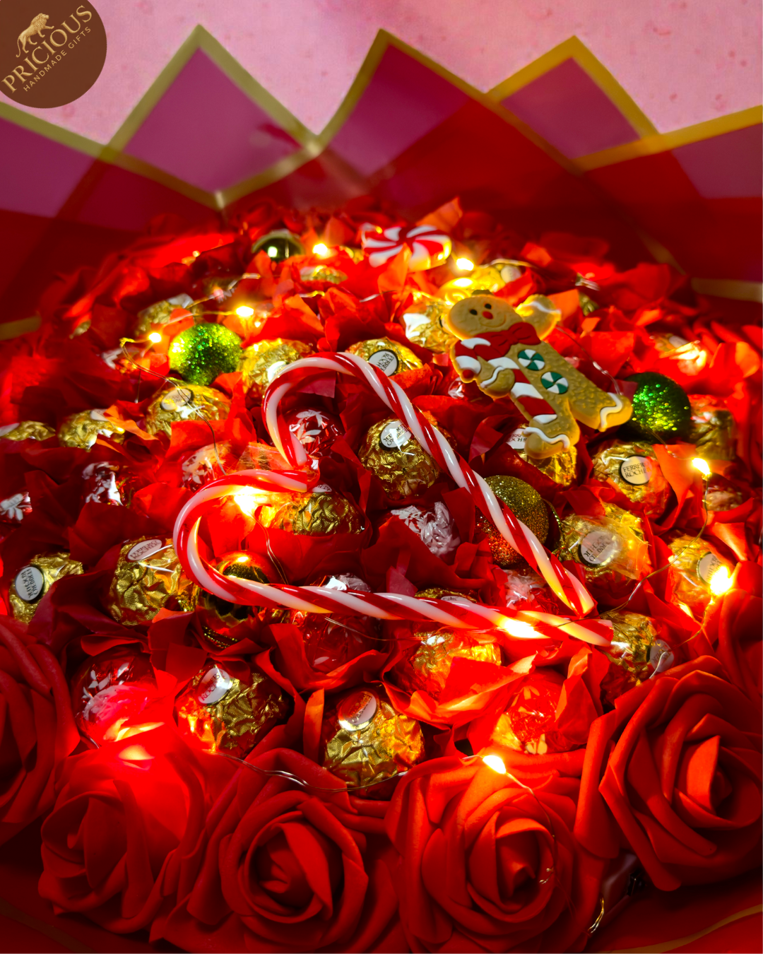 Red & gold hand-tied festive bouquet with Ferrero Rocher and Lindt Lindor, artificial roses and topper.