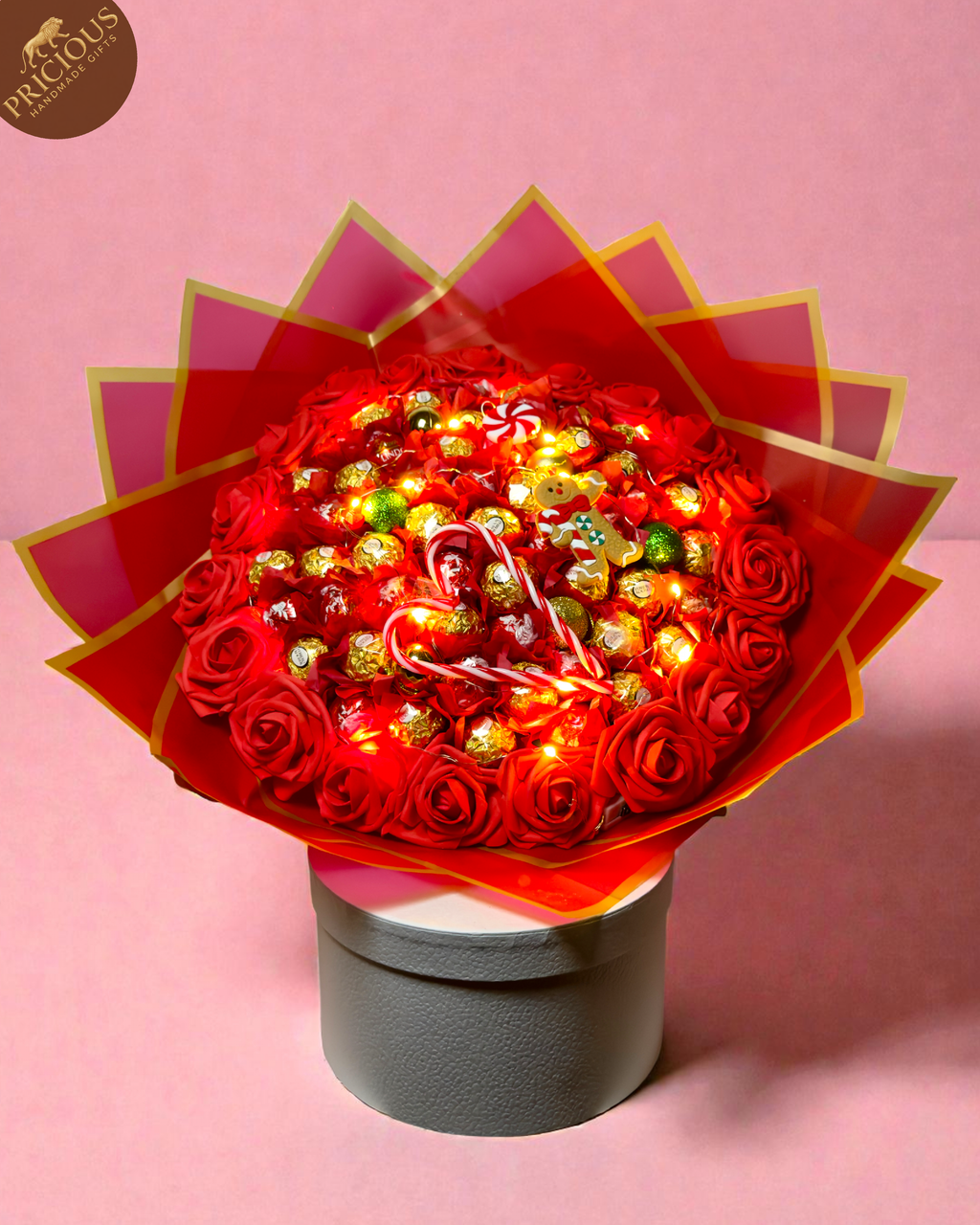 Red & gold hand-tied festive bouquet with Ferrero Rocher and Lindt Lindor, artificial roses and topper.