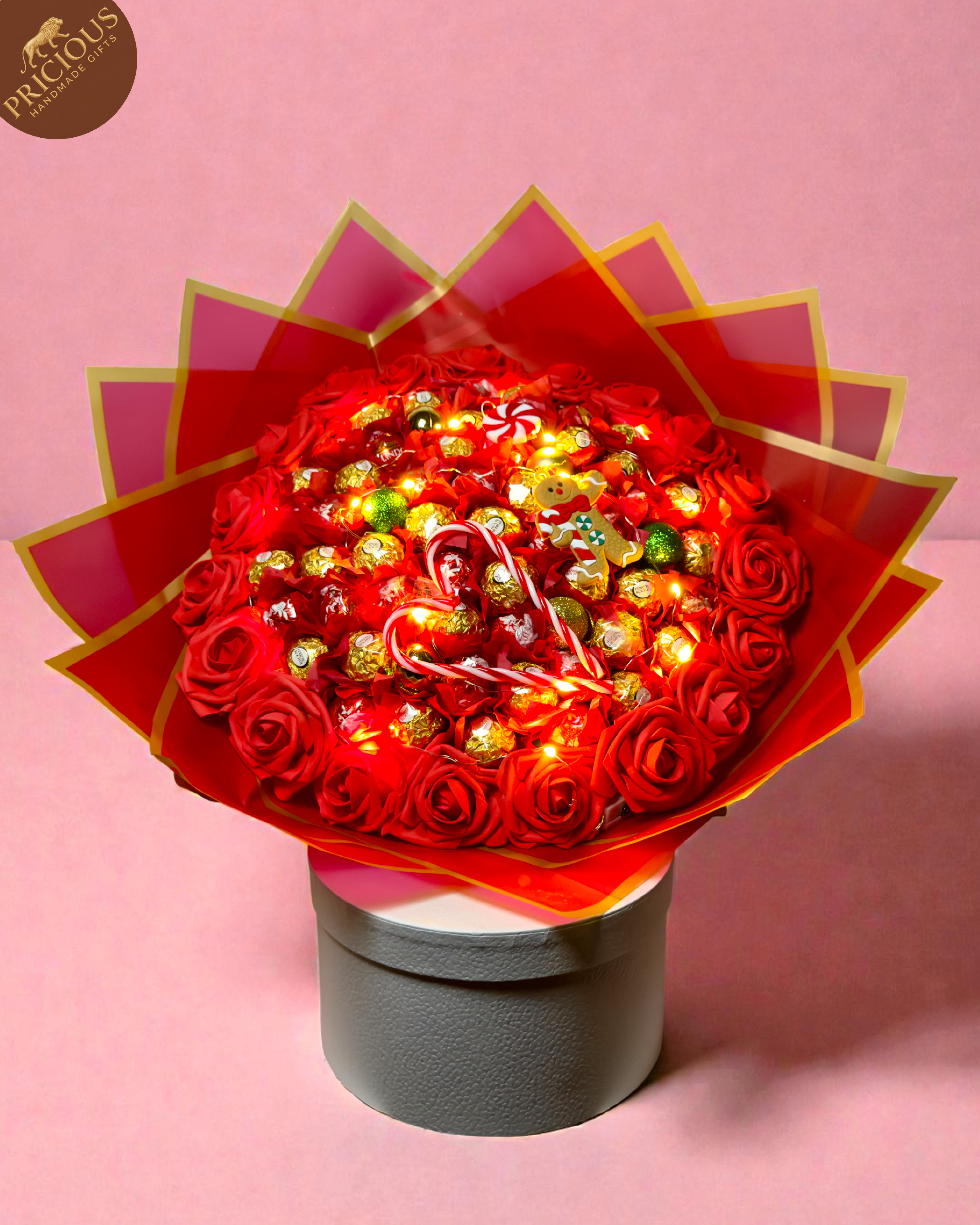 Red & gold hand-tied festive bouquet with Ferrero Rocher and Lindt Lindor, artificial roses and topper.