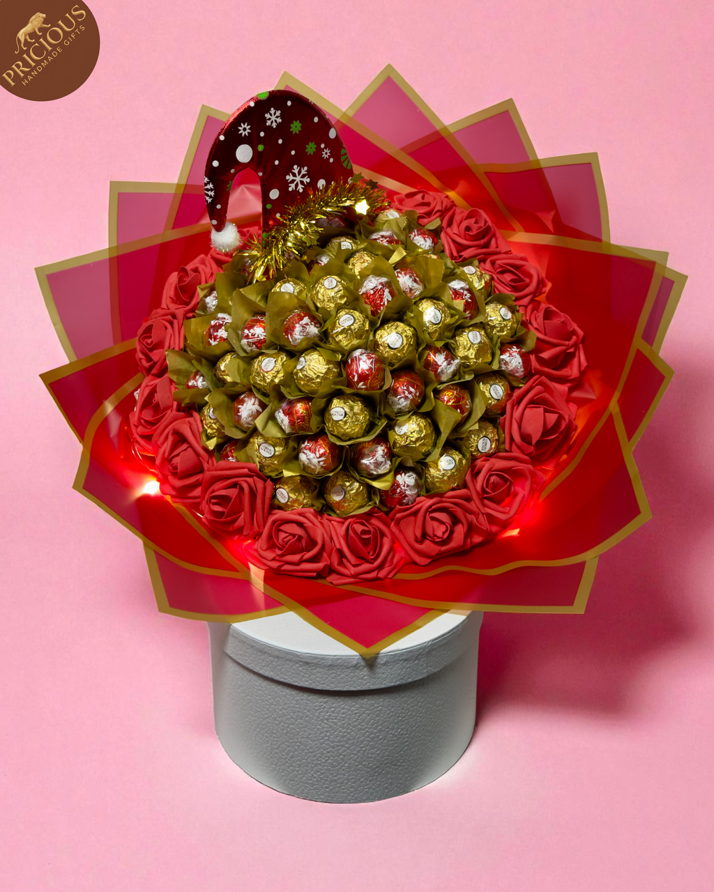 Top view of festive chocolate bouquet with foam roses, LED lights and Christmas topper.