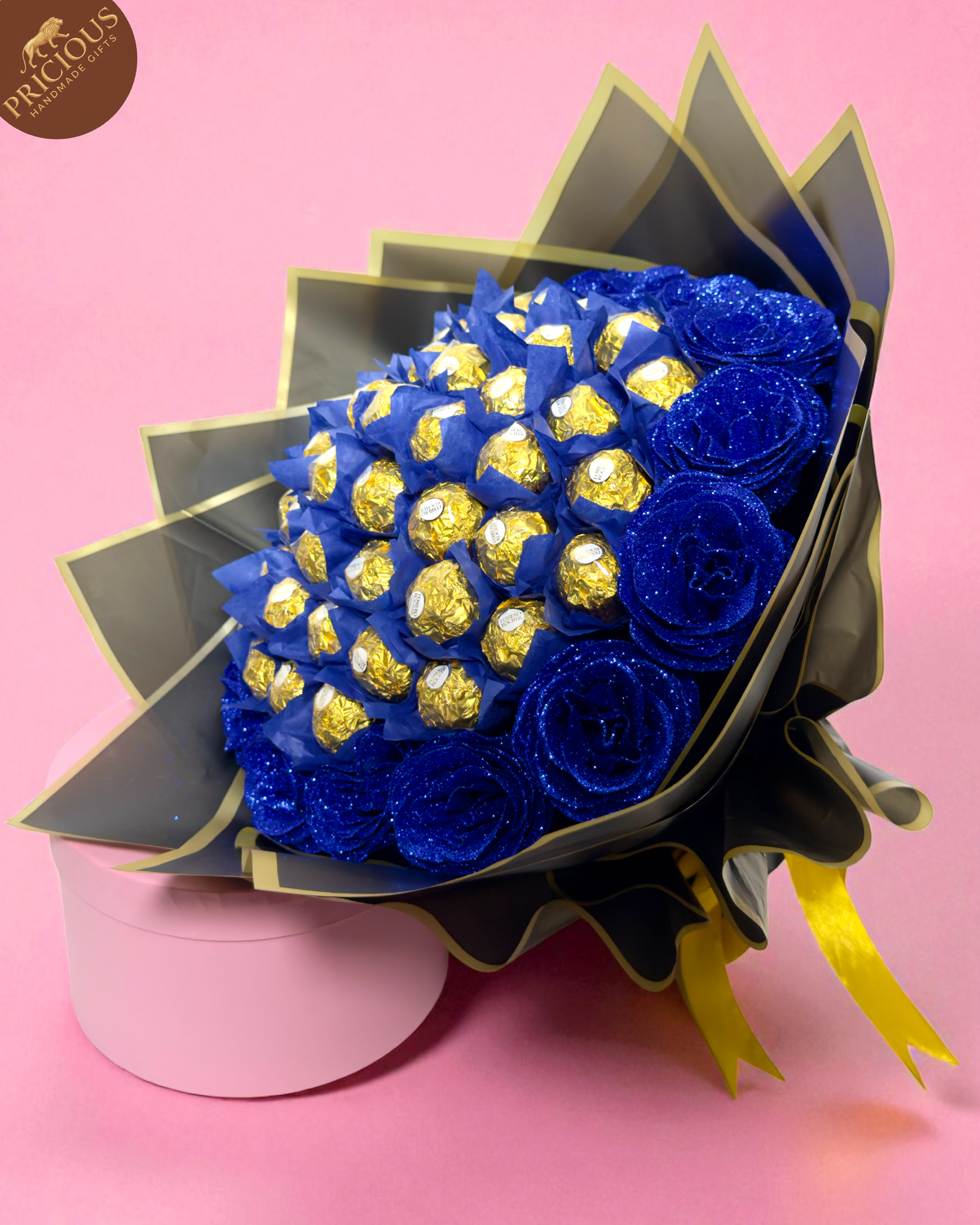 Hand-tied Ferrero Rocher chocolate bouquet with glitter blue artificial roses in black wrap with gold edging.