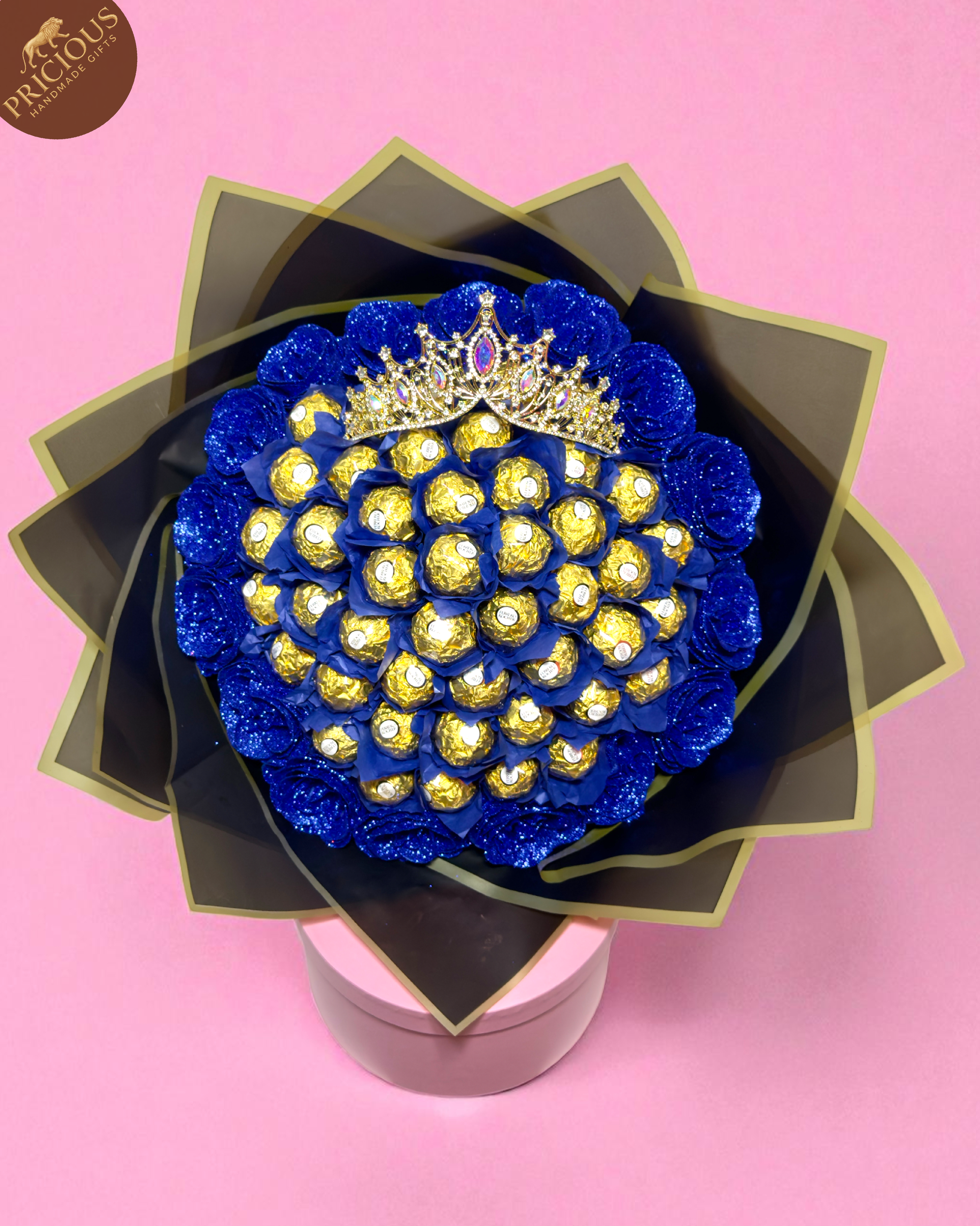 Royal blue glitter-rose chocolate bouquet (hand-tied), crown accent, luxury black-and-gold wrap.