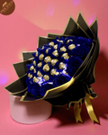 Hand-tied Ferrero Rocher bouquet with LED lights and glitter-blue artificial roses, black & gold wrap (angled view).