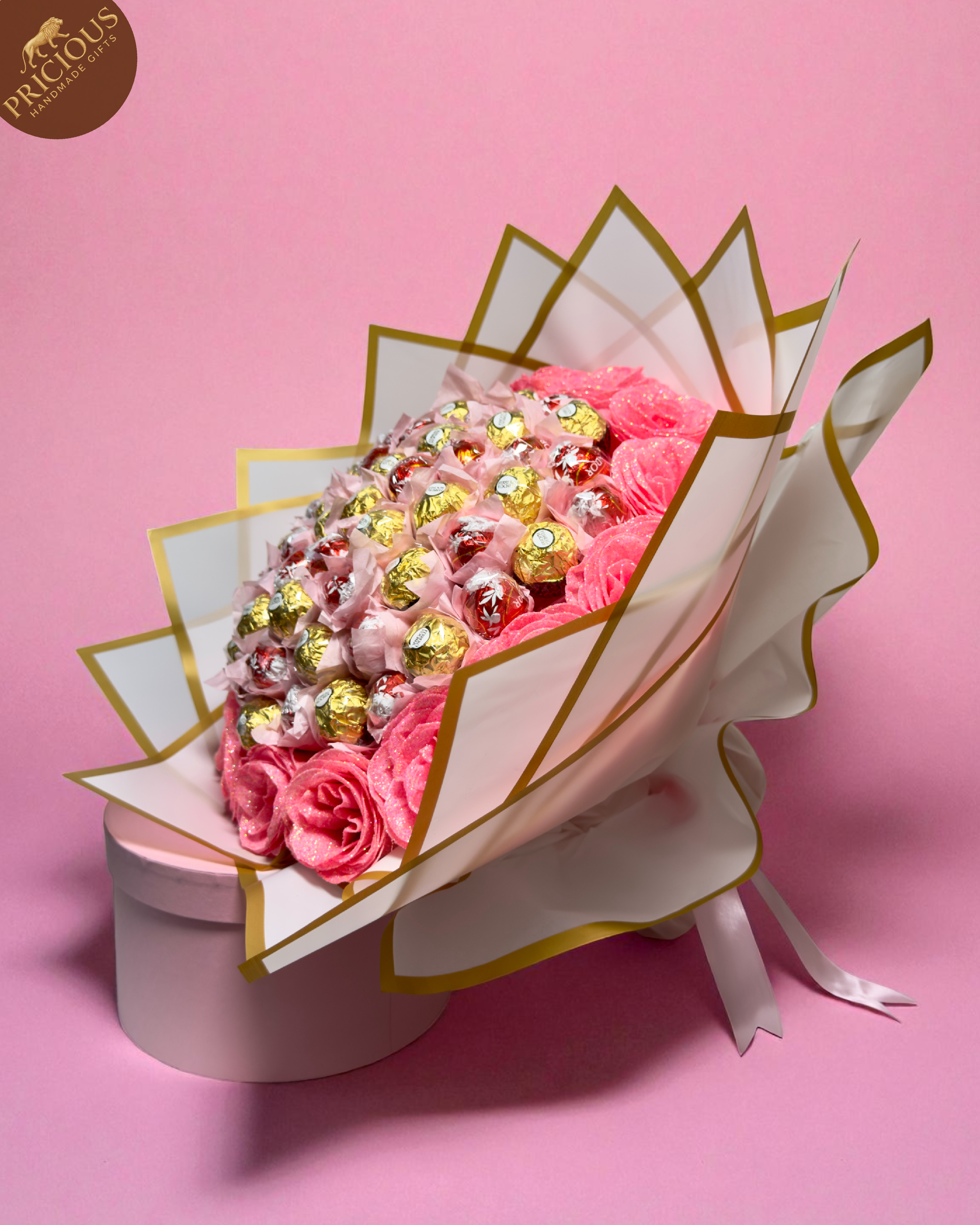Hand-tied chocolate bouquet with Ferrero Rocher & Lindt Lindor, pink glitter artificial roses and white-gold wrap.