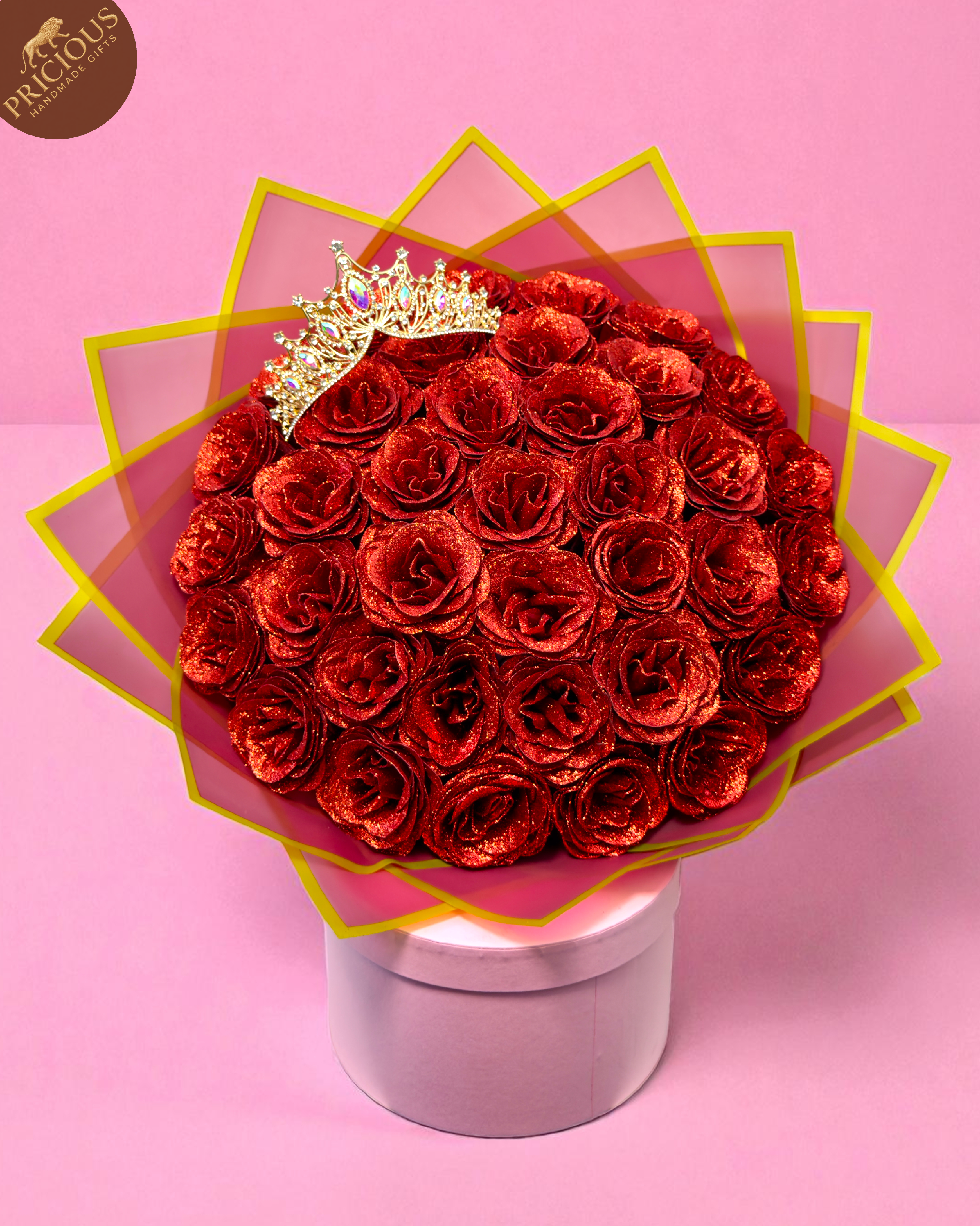 Hand-tied red glitter artificial-rose bouquet with tiara crown, layered pink & gold wrap (top view).