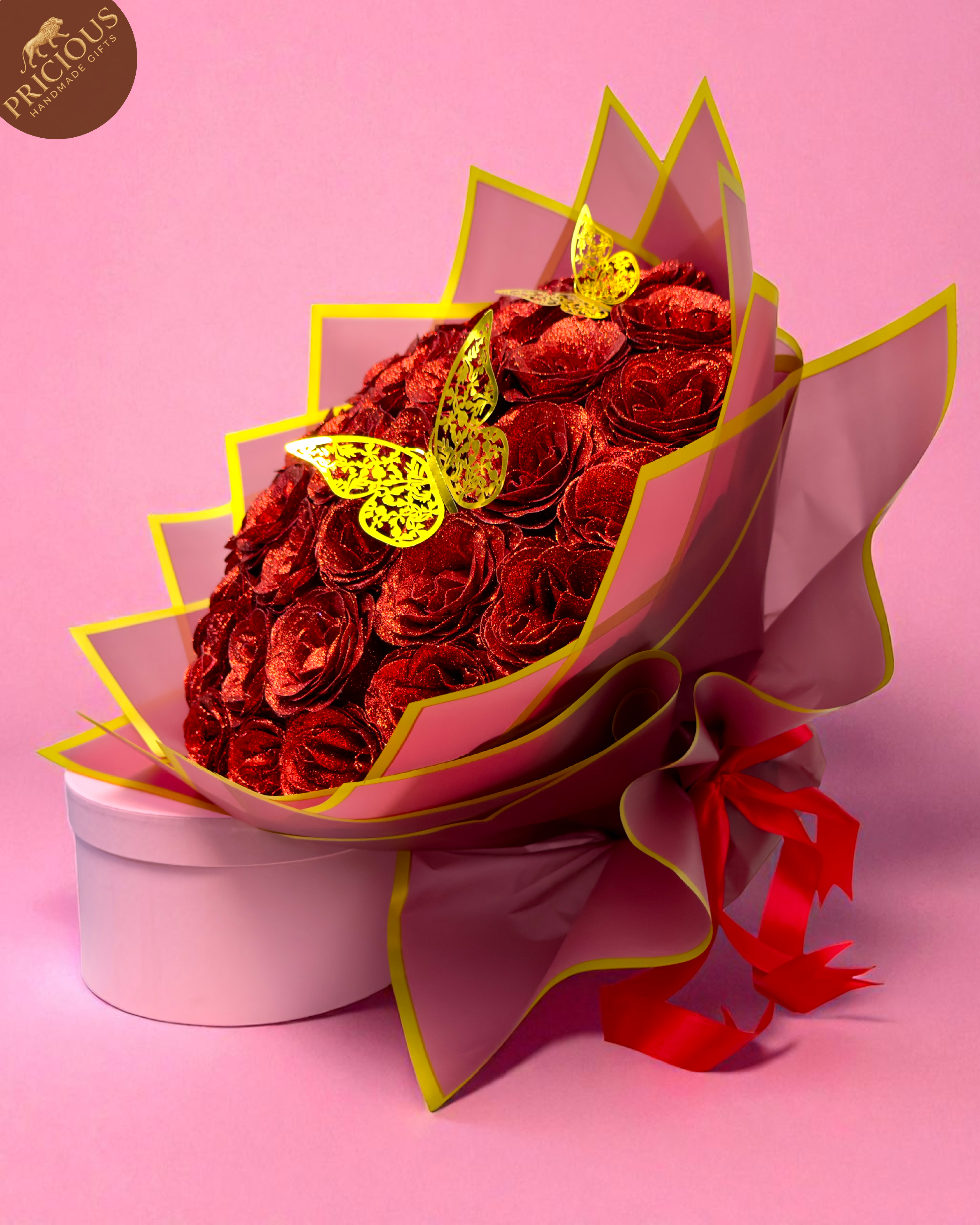 Hand-tied red glitter artificial roses bouquet with butterflies in pink & gold wrap.
