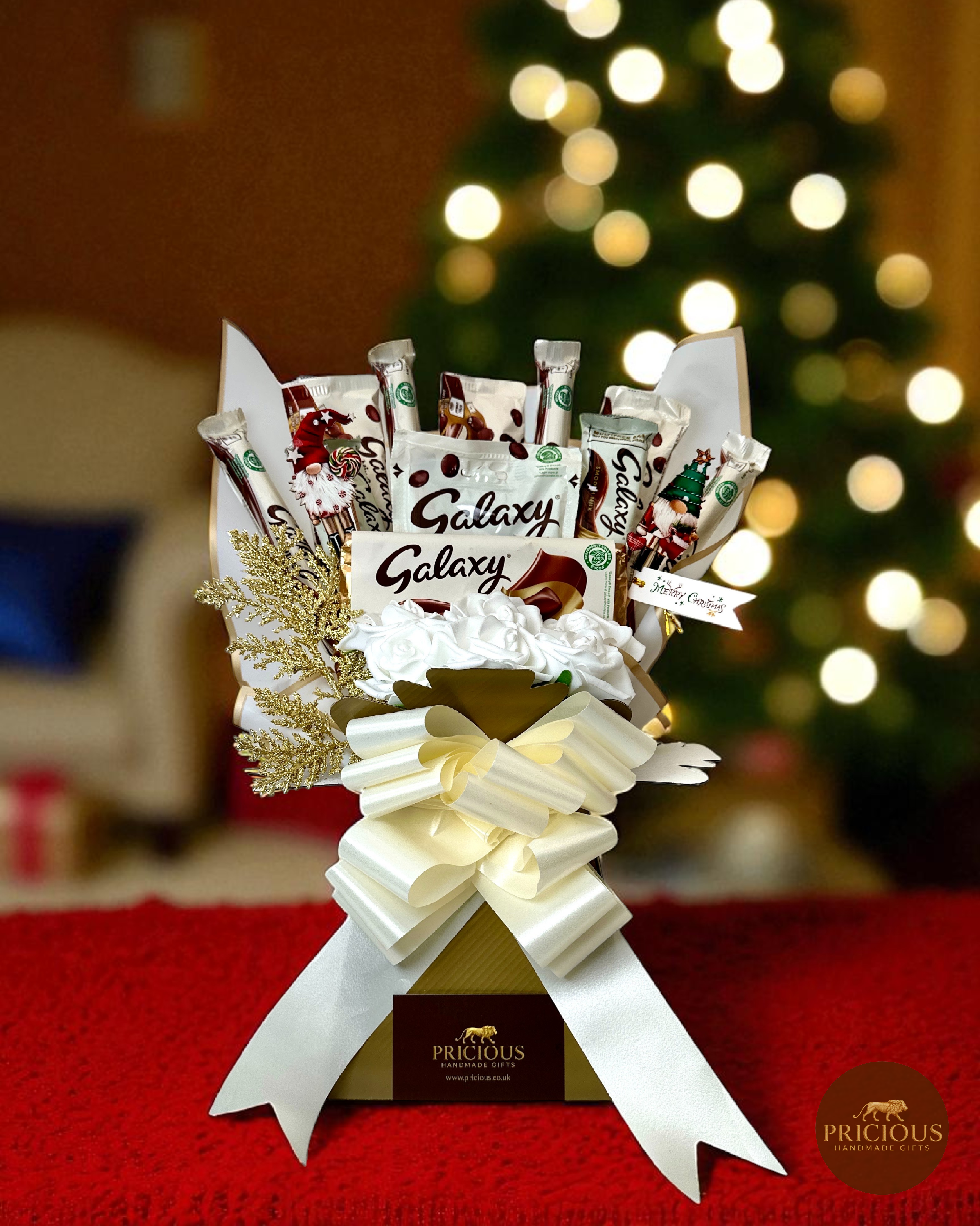Front view festive Galaxy bouquet with ivory bow and gold gift box.