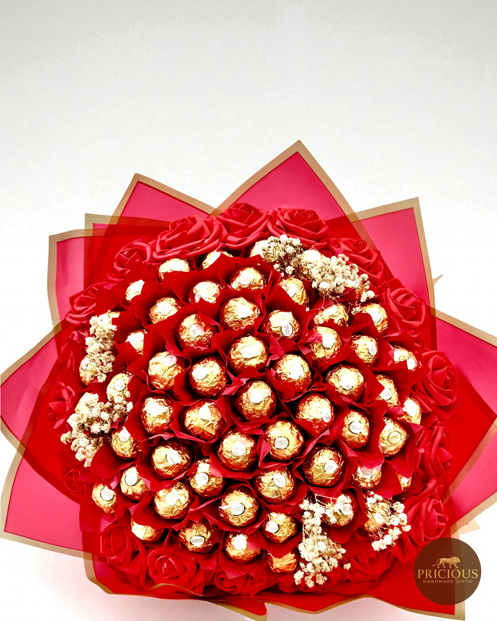 Bouquet of gold Ferrero Rocher chocolates and red roses in a decorative box with 'Precious' branding.