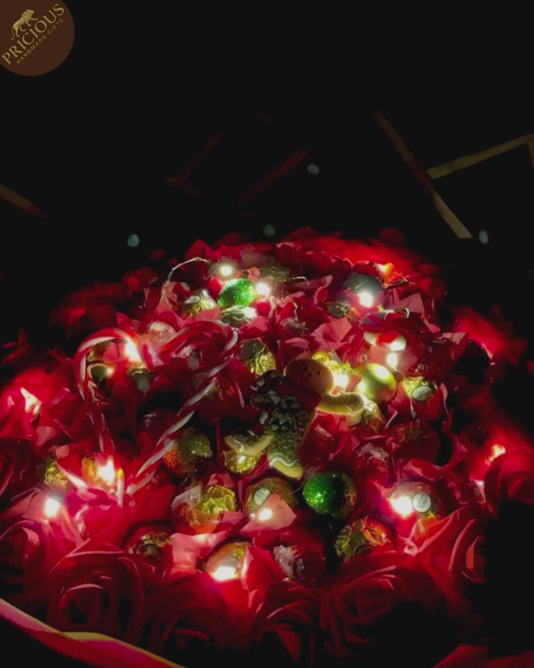 Red & gold hand-tied festive bouquet with Ferrero Rocher and Lindt Lindor, artificial roses and topper.