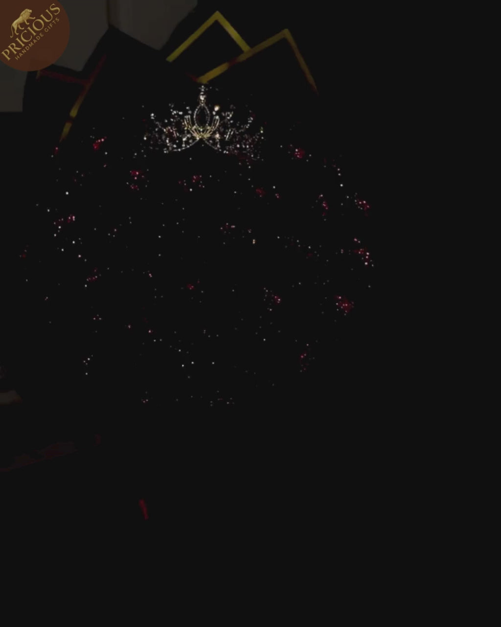 Hand-tied red glitter artificial-rose bouquet with tiara crown, layered pink & gold wrap (top view).