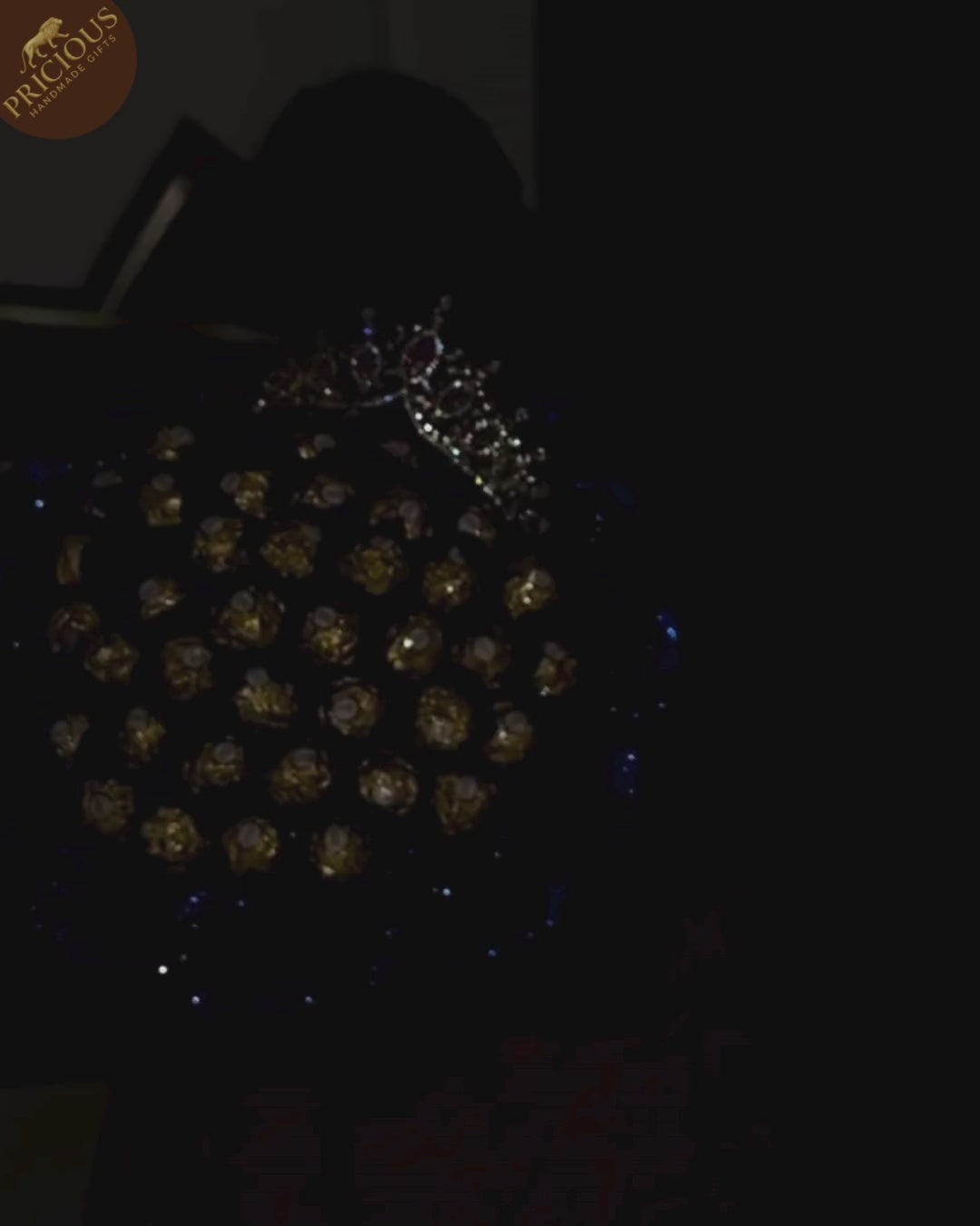 Royal blue glitter-rose chocolate bouquet (hand-tied), crown accent, luxury black-and-gold wrap.